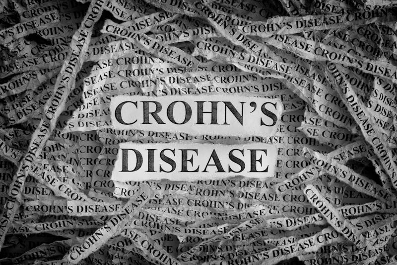 PJXDJT Crohn’s Disease. Torn pieces of paper with the words Crohn’s Disease. Concept Image. Black and White. Closeup.