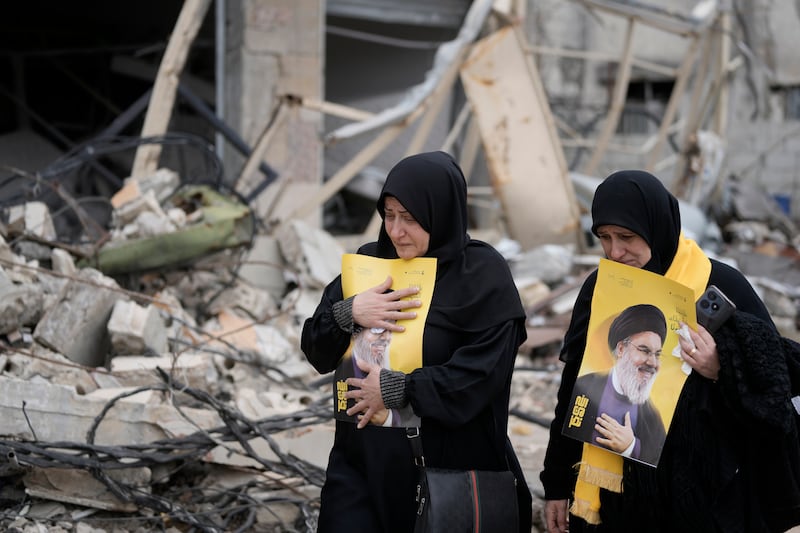 Lebanese women hold portraits of killed Hezbollah leader Sayyid Hassan Nasrallah (Bilal Hussein/AP)