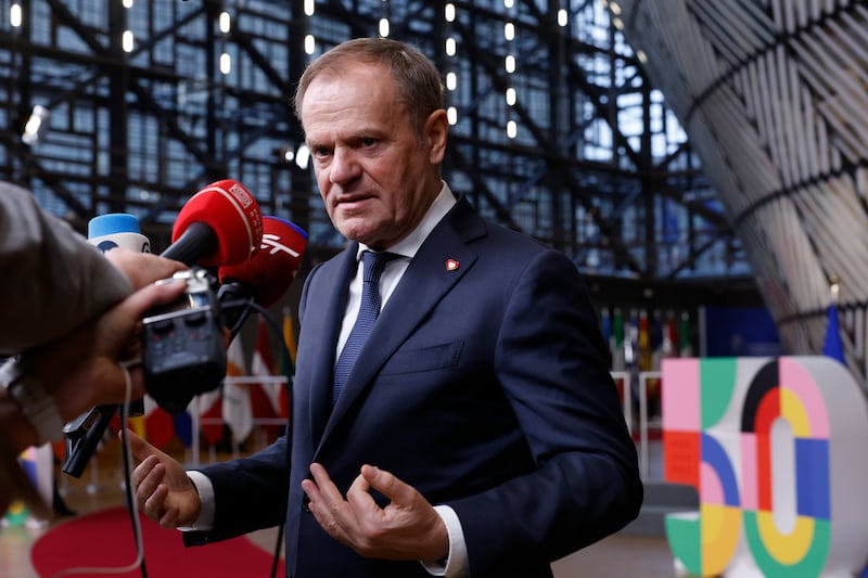 Poland’s Prime Minister Donald Tusk speaks with the media prior to a group photo at an EU summit in Brussels (Omar Havana/AP)