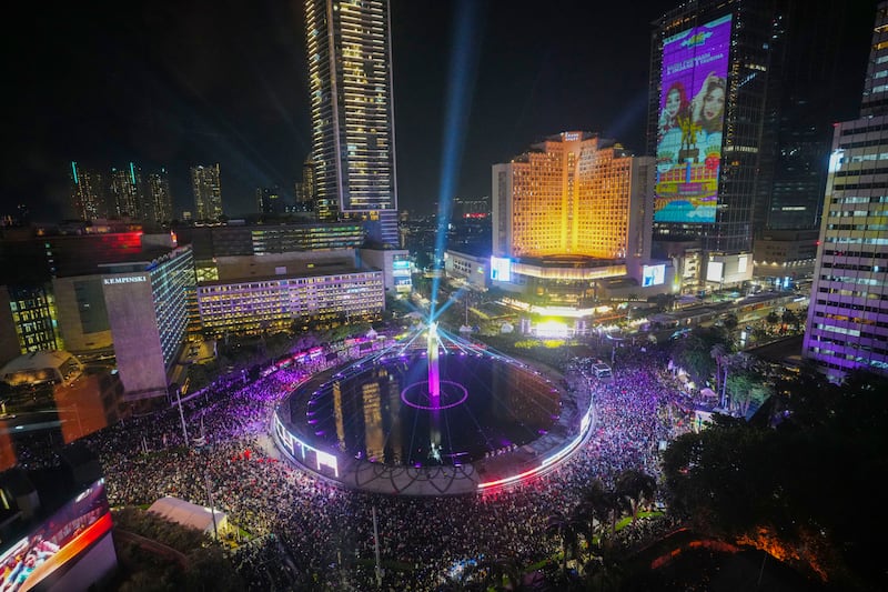 People gather in the main business district on New Year’s Eve in Jakarta, Indonesia (AP Photo/Tatan Syuflana)