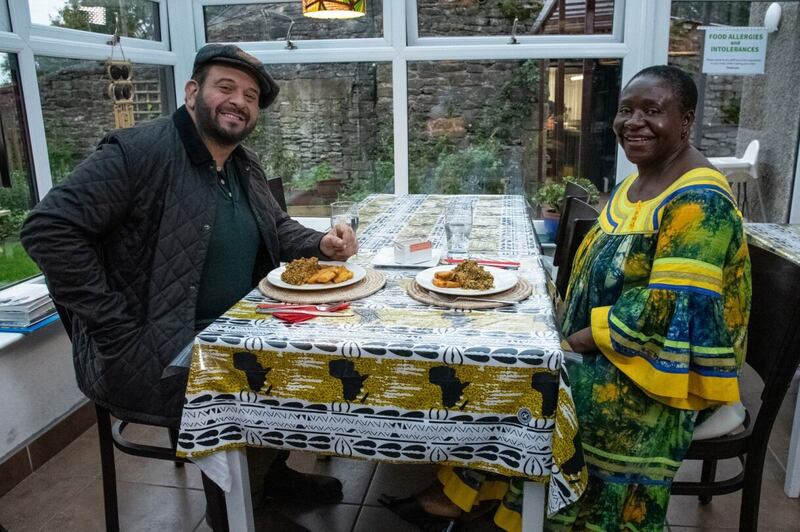 Richman dining with Stella Kisob Knowels in Stella’s Kitchen dining room with egusi soup