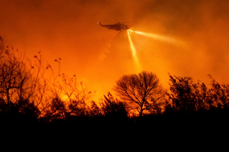 A helicopter drops water while fighting the Auto Fire in Ventura County (Noah Berger/AP)