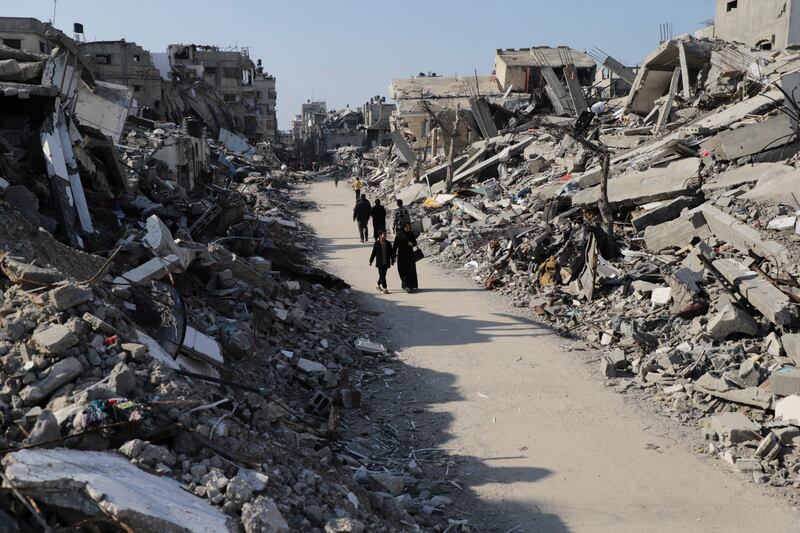 Palestinians walk through the destruction from the Israeli offensive in Jabaliya refugee camp in the Gaza Strip (AP Photo/Mahmoud Essa)