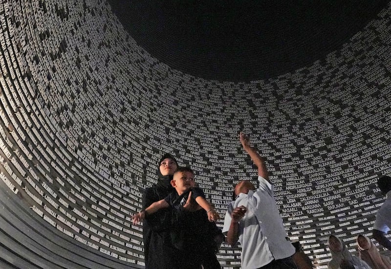 Visitors looks at a wall displaying the names of the victims of 2004 Indian Ocean tsunami, at the Tsunami Museum in Banda Aceh (Achmad Ibrahim/AP)