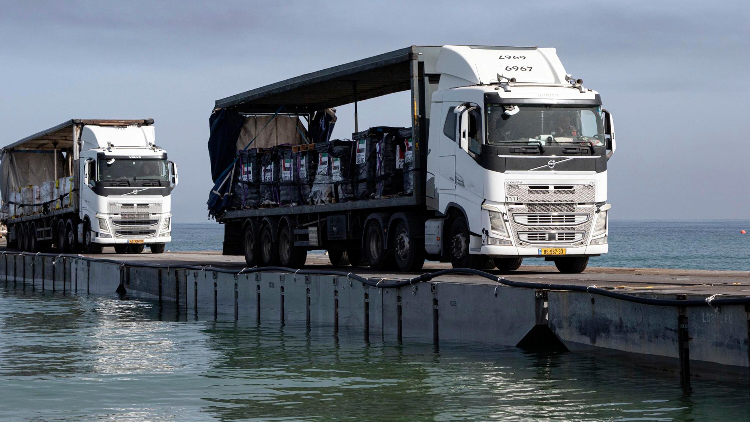 Lorries loaded with humanitarian aid cross the pier before arriving on the beach in the Gaza Strip (Staff Sgt Malcolm Cohens-Ashley/US Army via AP)