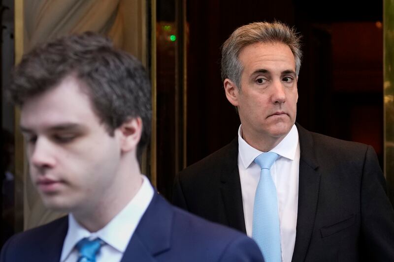 Michael Cohen, right, leaves his apartment building in New York (Seth Wenig/AP)