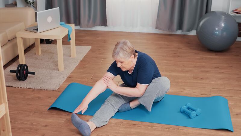 Senior woman stretching on a yoga mat