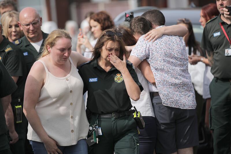 Emergency personnel and members of the public pay their respects at the scene of the attack