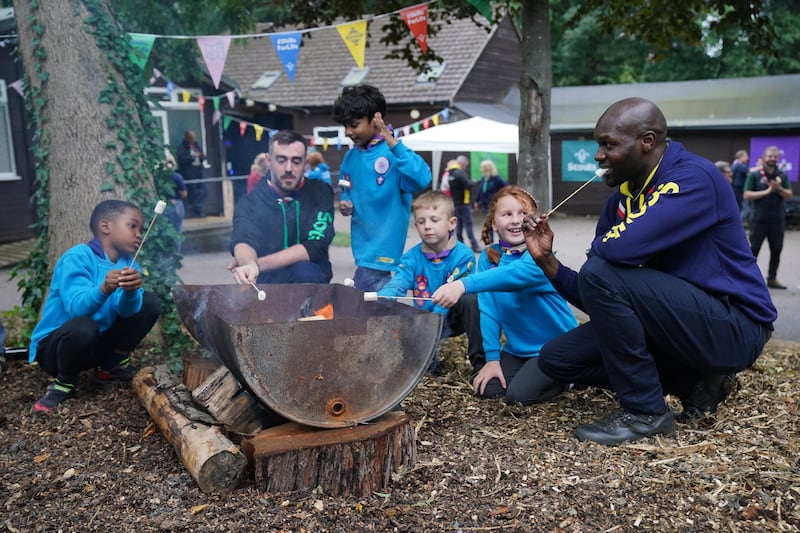 Dwayne Fields toasts marshmallows with a group of scouts at Scout Park in London after he was chosen to be the new UK chief scout