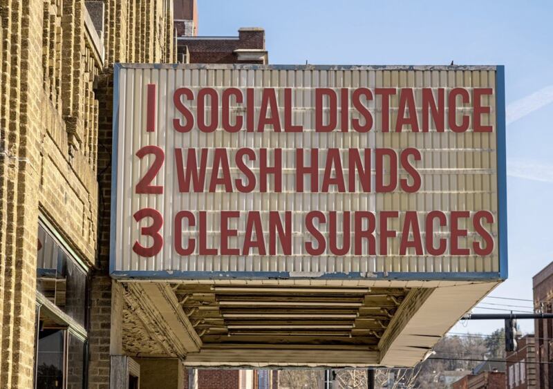 A sign tells people to wash hands, maintain social distance and clean surfaces 