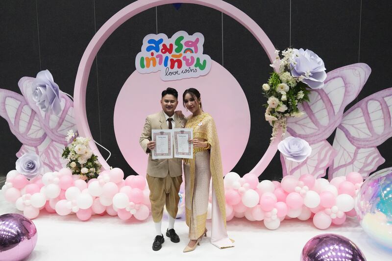 A couple from the LGBTQ+ community show their marriage certificate in Bangkok (Sakchai Lalit/AP)