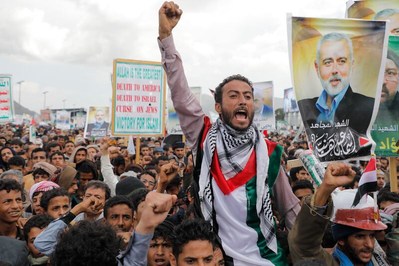 Houthi supporters hold posters showing Ismail Haniyeh, a Hamas leader assassinated in Tehran during a rally in Sanaa, Yemen (Osamah Abdulrahman/AP)