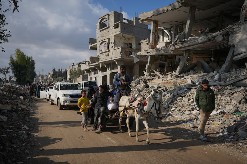 Palestinians carry UN-donated flour in Khan Younis, in central Gaza, on Saturday (Abdel Kareem Hana/AP)