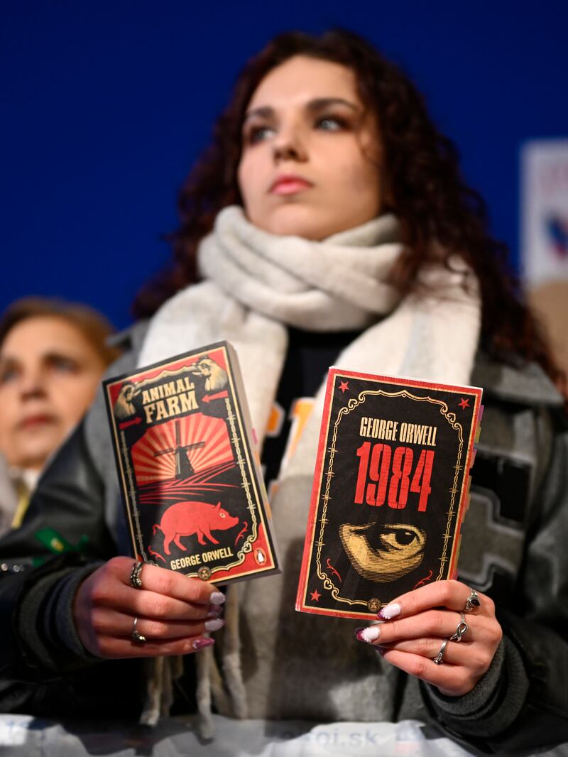 A woman holds books as thousands gather to oppose the policies of Slovakia’s Prime Minister Robert Fico in Bratislava, Slovakia (Denes Erdos/AP)