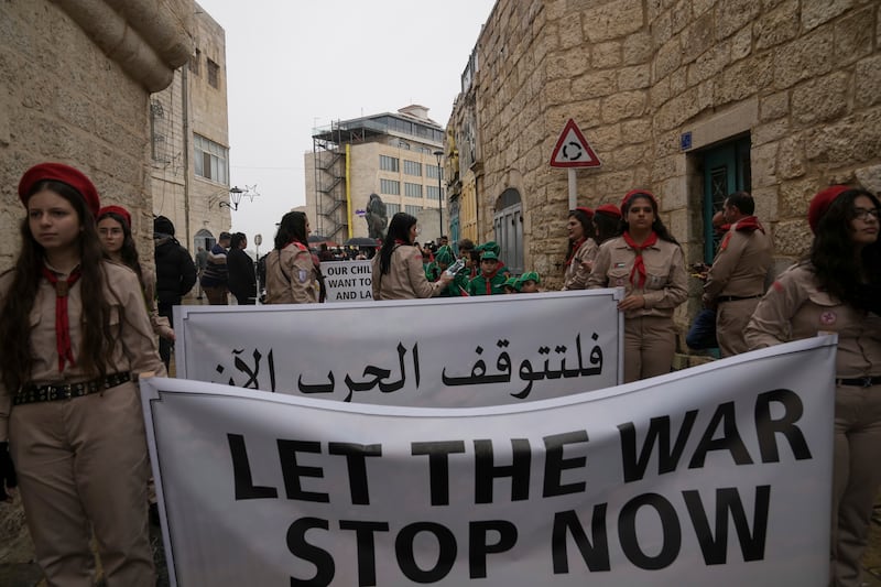 Palestinian scouts hold signs in solidarity with Palestinians in the Gaza Strip calling to end the Israel-Hamas war (AP Photo/Mahmoud Illean)