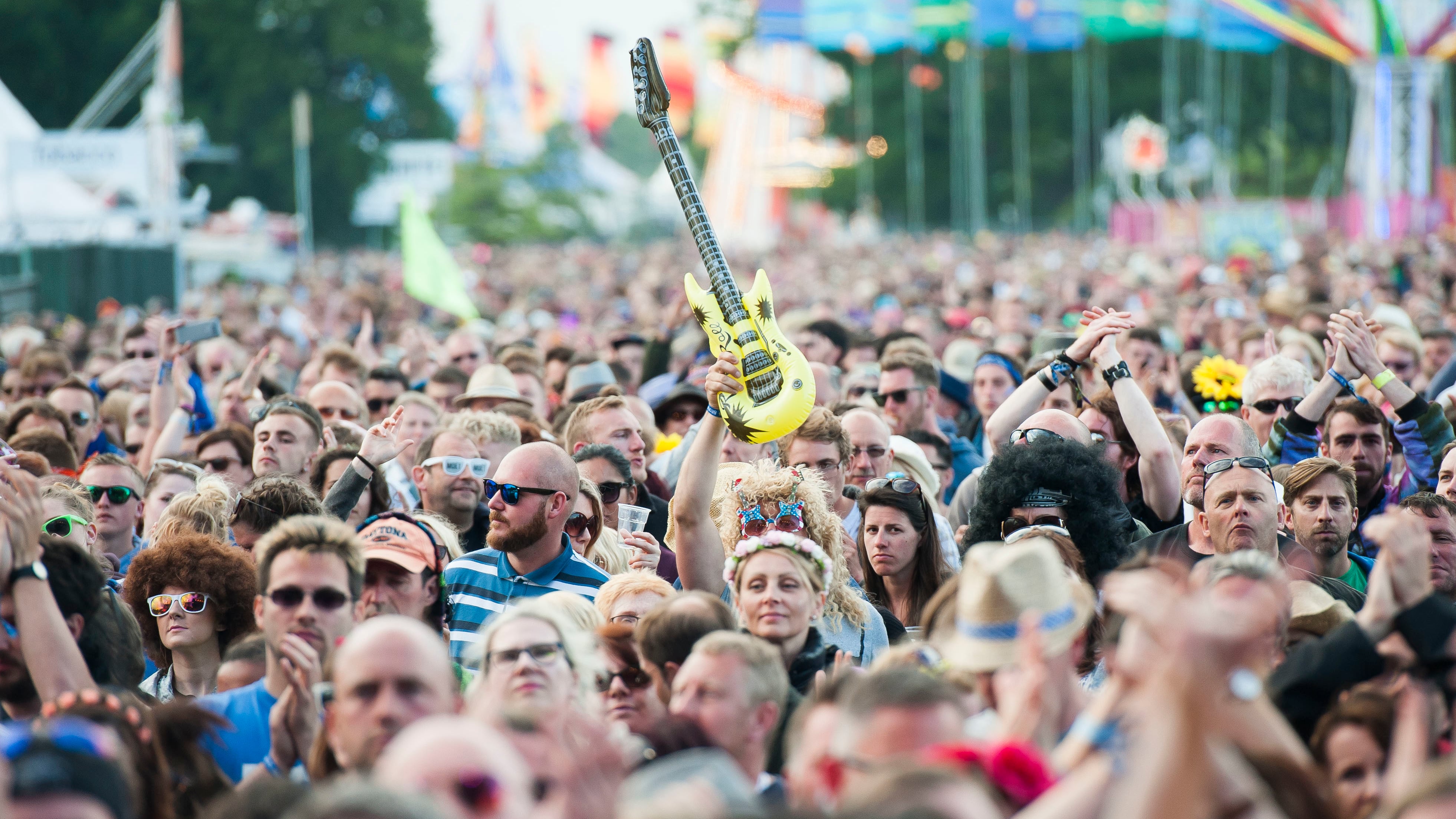 A festival goer holds an inflatable guitar at the Isle of Wight Festival, Seaclose park, Newport, on the Isle of Wight