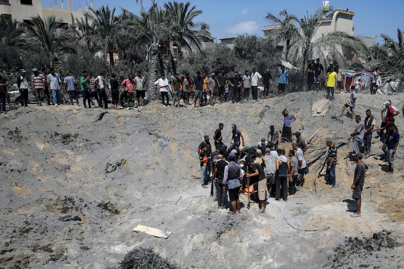 Palestinians search for bodies and survivors after an Israeli bombardment on Khan Younis (Jehad Alshrafi/AP)