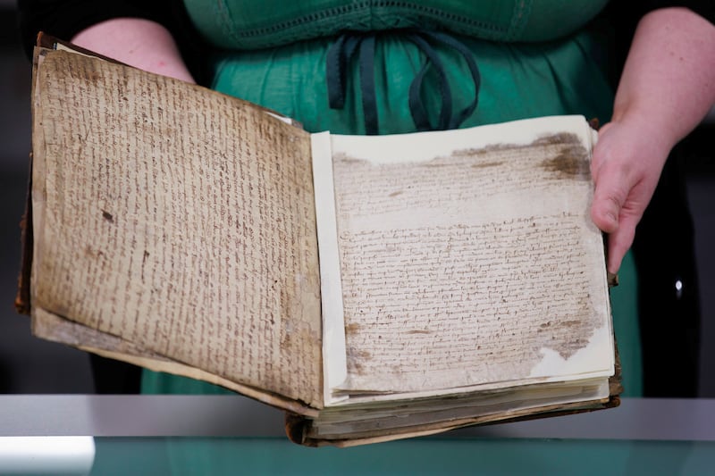 Sarah Graham, head of conservation at PRONI, holding one of the oldest paper documents still in existence on the island of Ireland, at the Public Record Office of Northern Ireland (PRONI) in Belfast. PA Photo. Picture date: Monday December 16 2024. See PA story ULSTER Archive. Photo credit should read: Liam McBurney/PA Wire