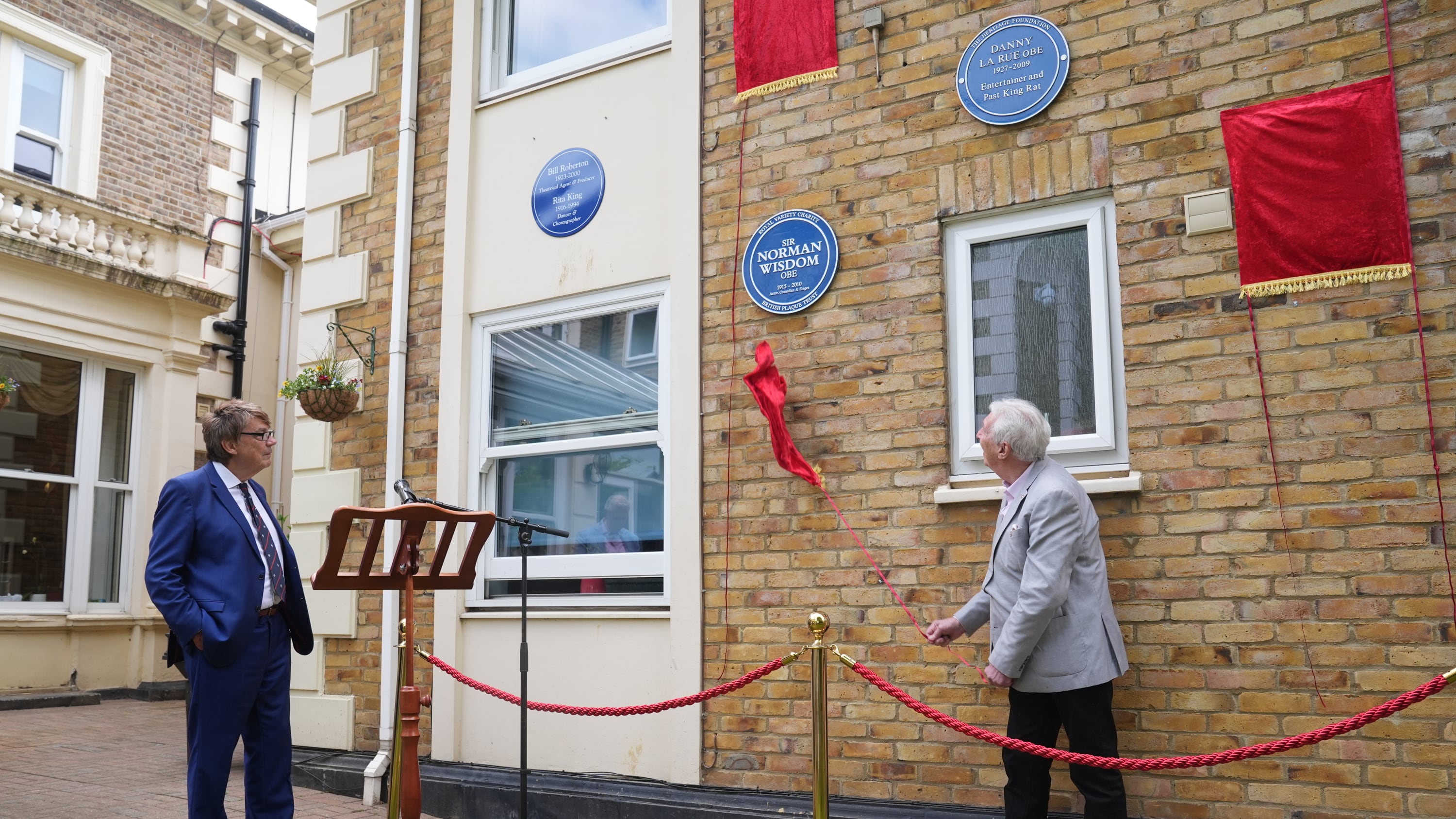 DJ Mike Read watches as Johnny Mans, who represented Sir Norman Wisdom, unveils a Blue Plaque in his name