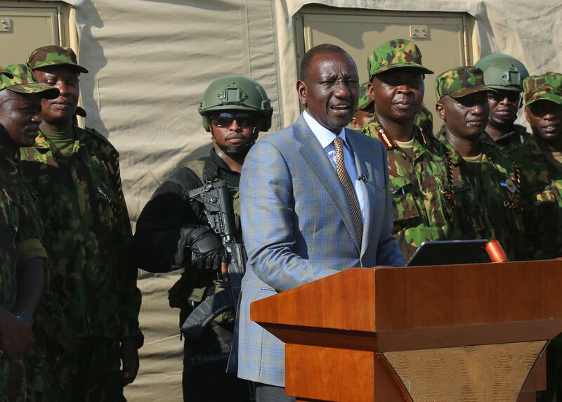 Mr Ruto speaks to Kenyan police officers, part of a UN-backed multinational force, during a visit to their base (Odelyn Joseph/AP)