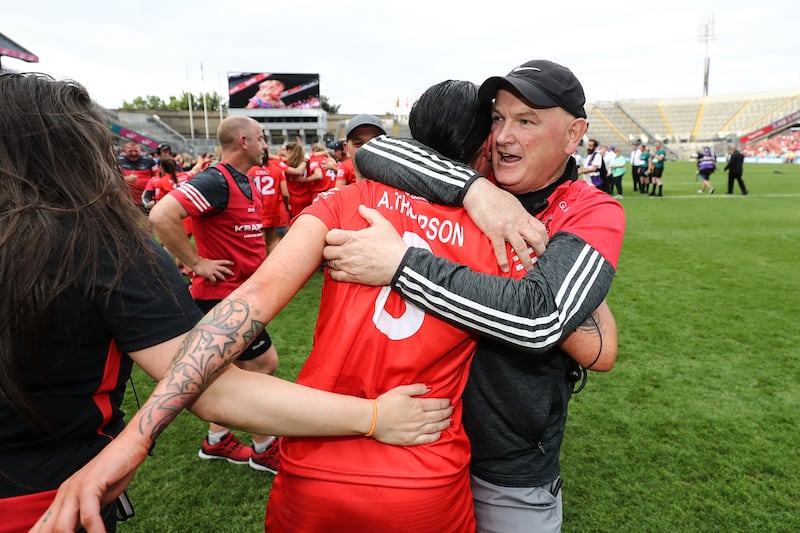 Cork's Ashling Thompson celebrates after the senior camogie final with manager Ger Manley.