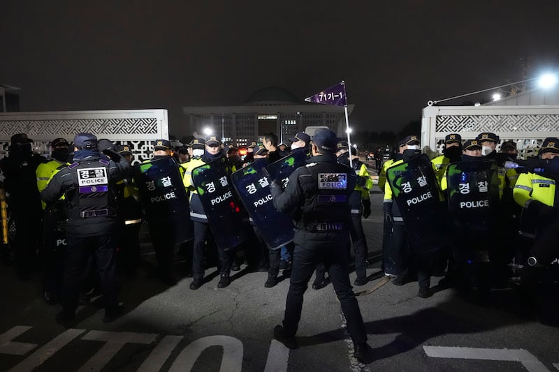 Police officers stand guard in front of the National Assembly in Seoul, South Korea (Lee Jin-man/AP)