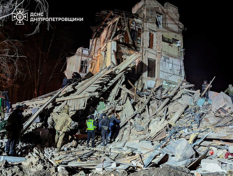 Ukrainian firefighters at an apartment building destroyed by a Russian attack in Kryvyi Rih (Ukrainian Emergency Service/AP)