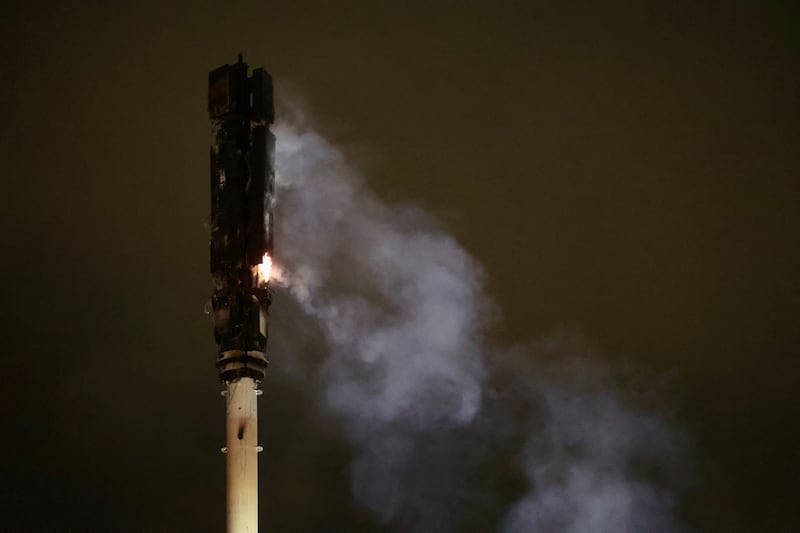 Firefighters tackle a fire at a 5g mast at Owenvarragh Park in Andersonstown. PICTURE: MAL MCCANN