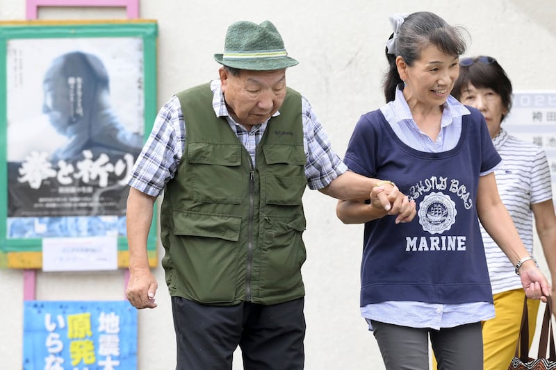 Iwao Hakamada is helped by a supporter as he goes for a walk in Hamamatsu in Shizuoka prefecture, central Japan (Kyodo News/AP)