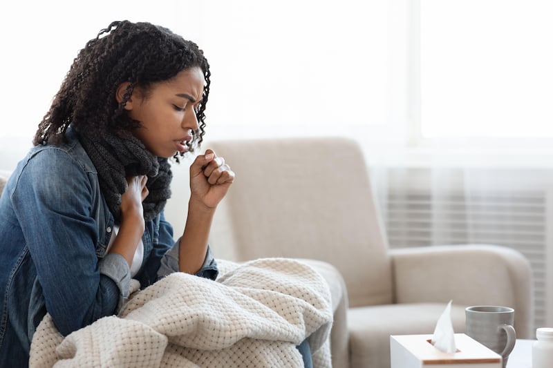 Sick young woman coughing hard at home