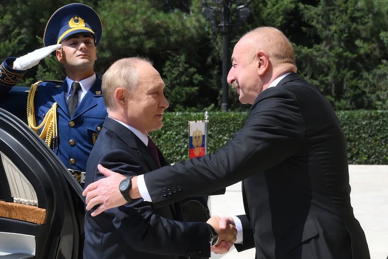 Azerbaijani President Ilham Aliyev, right, greets Russian President Vladimir Putin, left, at Zagulba state residence in Baku, Azerbaijan (Grigory Sysoyev/AP)