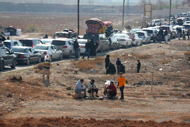 Lebanese families sit in traffic as they return to Lebanon through the Jousieh border crossing in Qusair, Syria (Omar Sanadiki/AP)