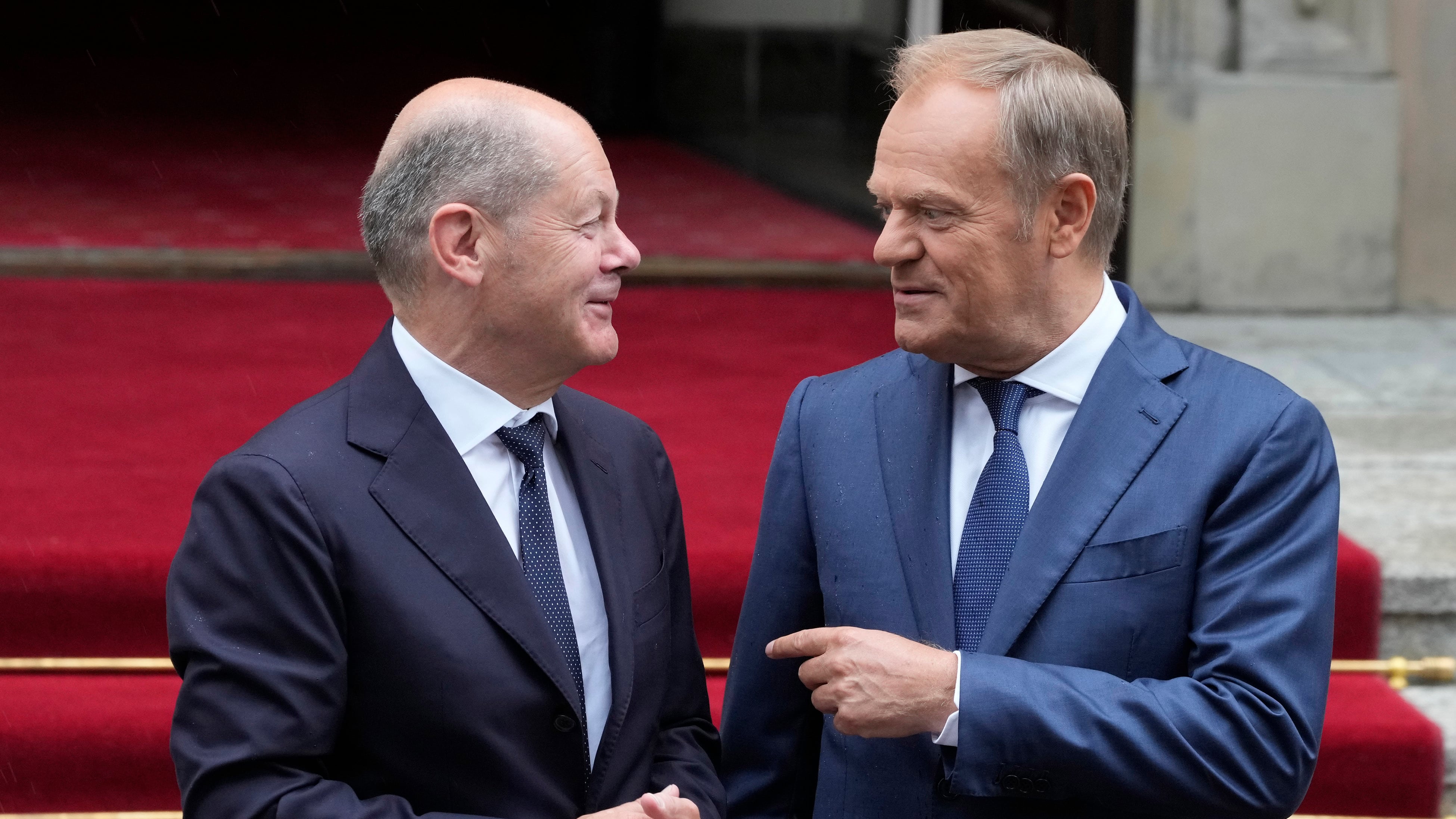 German Chancellor Olaf Scholz, left, and Polish Prime Minister Donald Tusk review the guard of honour before German-Polish inter-governmental consultations in front of Prime Minister Chancellery in Warsaw, Poland (Czarek Sokolowski/AP)