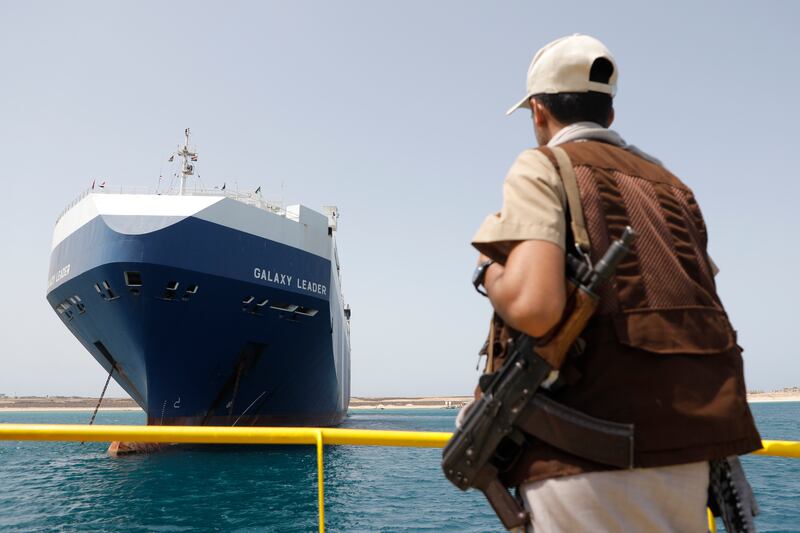 A Houthi soldier stands alert in front of the Israeli Galaxy ship which was seized by the Houthis, in the port of Saleef, near Hodeidah, Yemen (Osamah Abdulrahman/AP)
