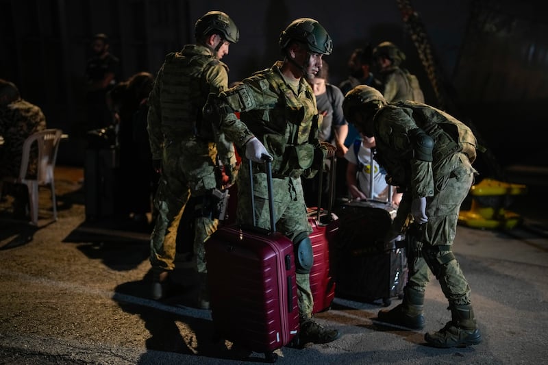 Turkish military personnel carry luggage of Turkish citizens to be evacuated on Turkish military ships from Lebanon to Turkey, in Beirut port (Emrah Gurel/AP)