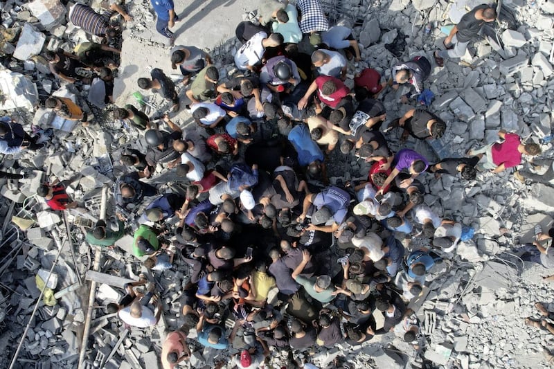 Palestinians look for survivors of the Israeli bombardment in the Maghazi refugee camp in the Gaza Strip 