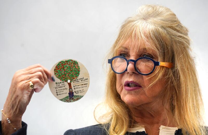 Pattie Boyd holding an original design doodle for an Apple Records LP label by George Harrison