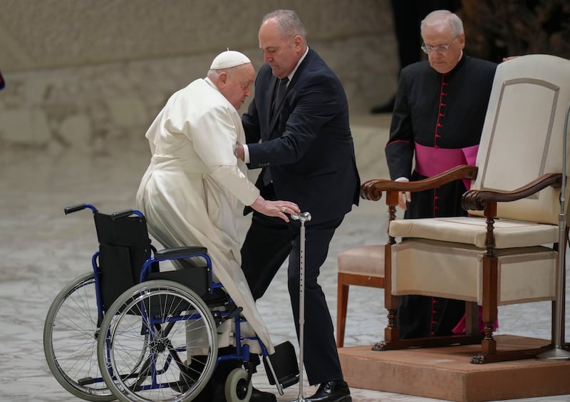 Pope Francis is helped by his assistant Piergiorgio Zanetti as he arrives for his weekly general audience in the Paul VI Hall at the Vatican on Wednesday (Alessandra Tarantino/AP)