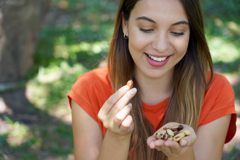 Close-up of woman eating Brazil nuts in the park