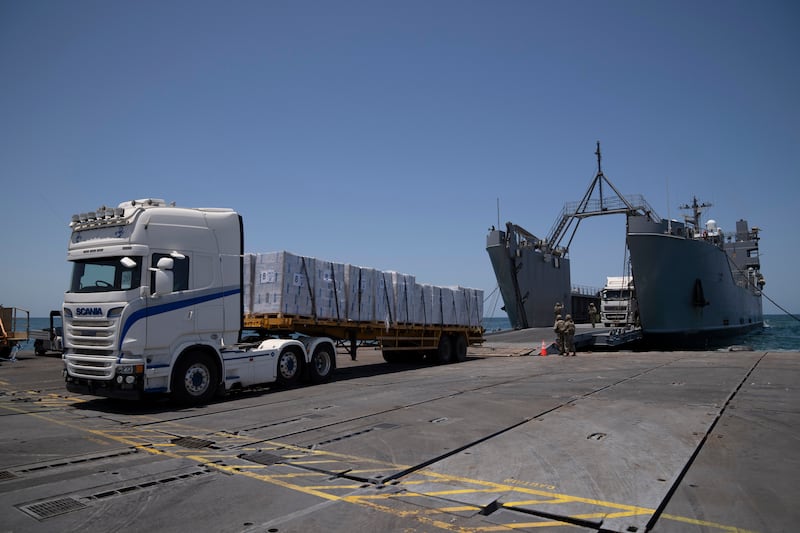 US Army soldiers stand next to trucks arriving loaded with humanitarian aid at the US-built floating pier (Leo Correa/AP)