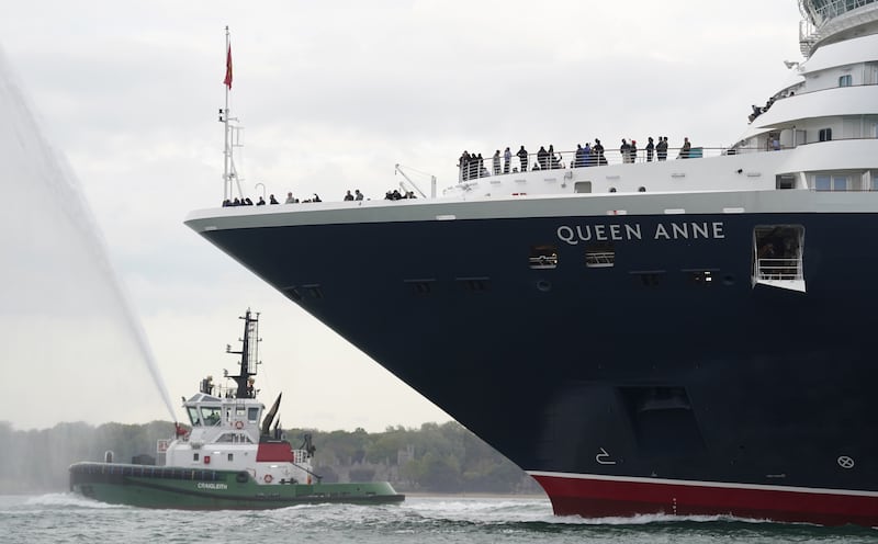 Tug boats sprayed water as the ship arrived