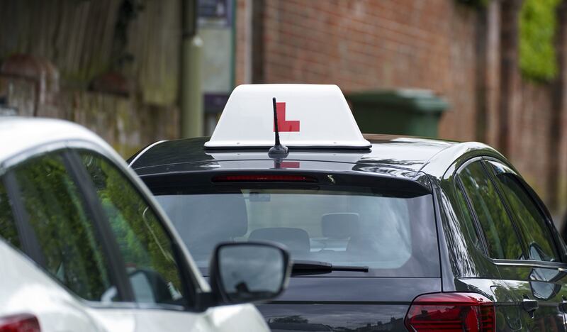 A learner driver drives down a street