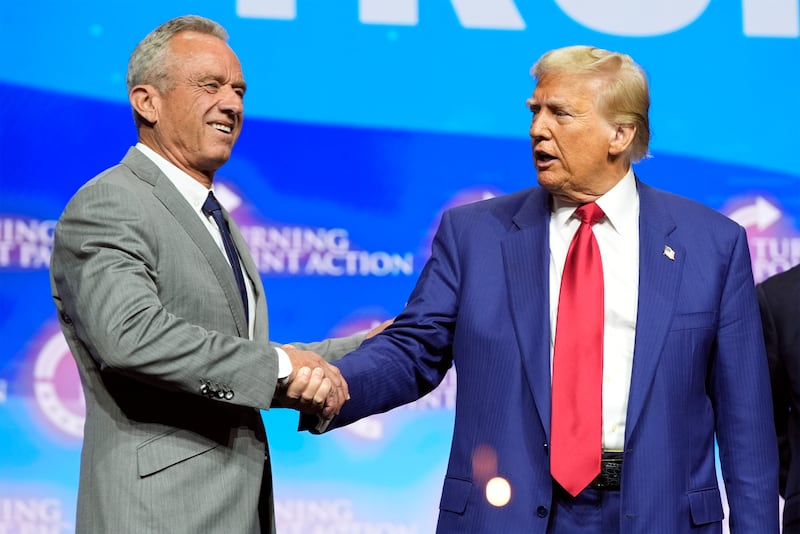 Republican presidential nominee former President Donald Trump shakes hands with Robert F Kennedy Jr, at a Turning Point Action campaign rally (AP Photo/Alex Brandon)