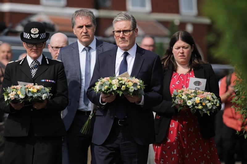 Prime Minister Sir Keir Starmer is seen carrying a floral tribute