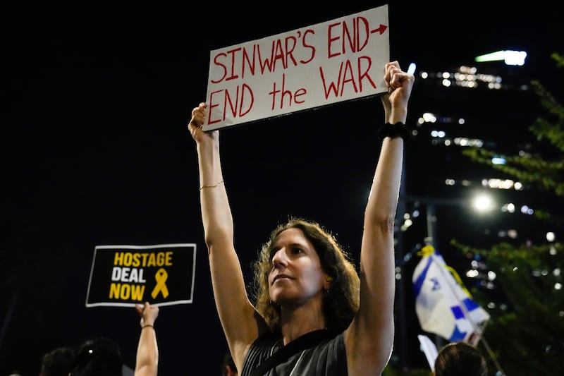 A demonstrator holds a sign during a protest calling for a ceasefire deal and the immediate release of hostages held by Hamas, in Tel Aviv on Thursday (Ariel Schalit/AP)