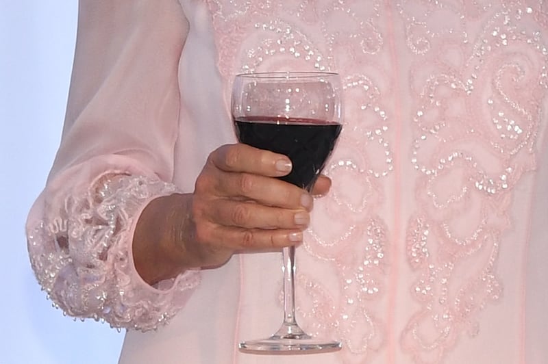 A person holding a glass of wine