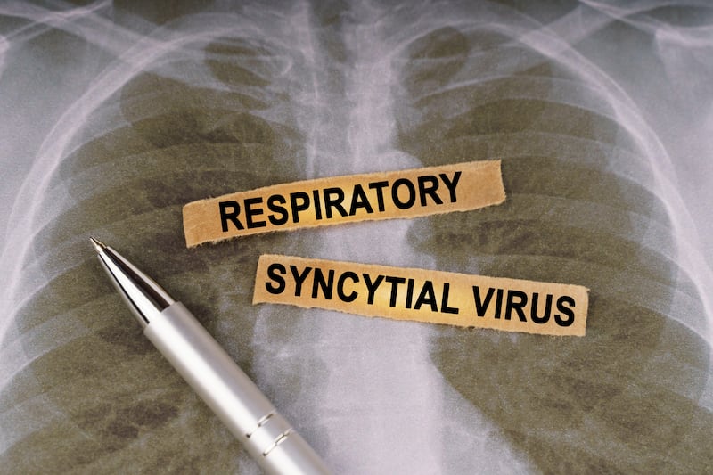 A pen and strips of paper labelled Respiratory Syncytial Virus on top of a human chest X-ray