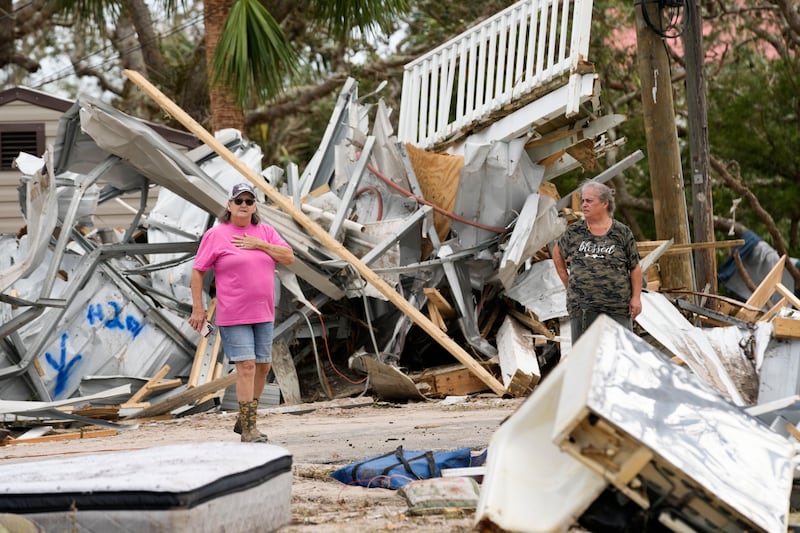 Frankie Johnson, left, talks with fellow resident Charlene Huggins, whose home was destroyed, amid the destruction in the aftermath of Hurricane Helene, in Horseshoe Beach, Florida (Gerald Herbert/AP)