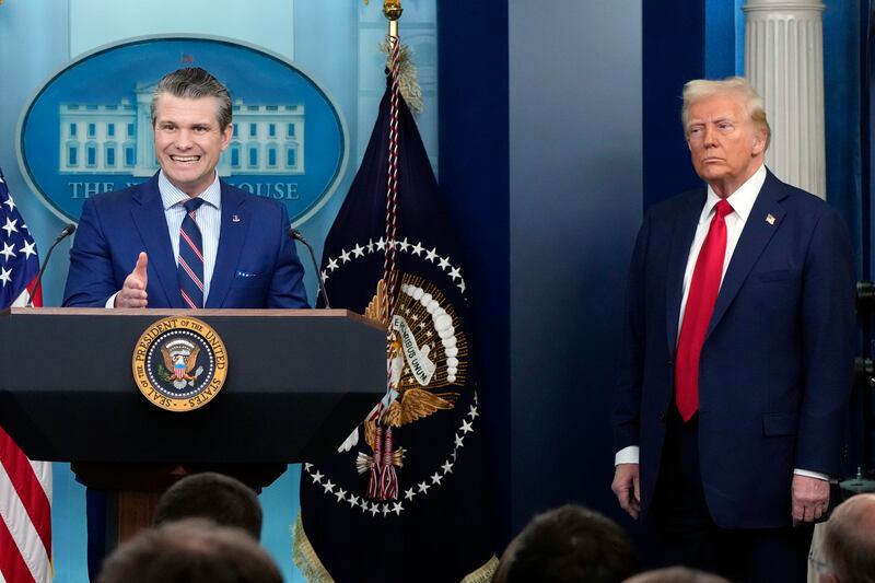 President Donald Trump listens as Defence Secretary Pete Hegseth speaks in the James Brady Press Briefing Room at the White House (Alex Brandon/AP)