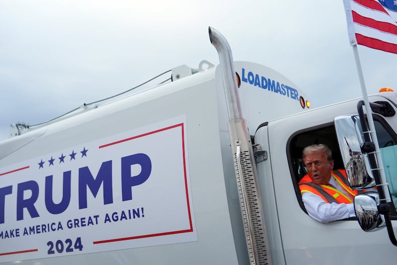 Republican presidential nominee former President Donald Trump talks to reporters as he sits in a garbage truck (Julia Demaree Nikhinson/AP)